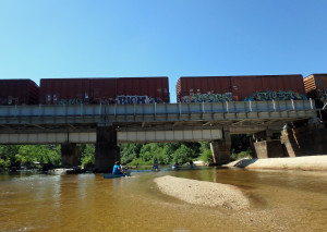 Paddlers passing beneath the railroad trestle.